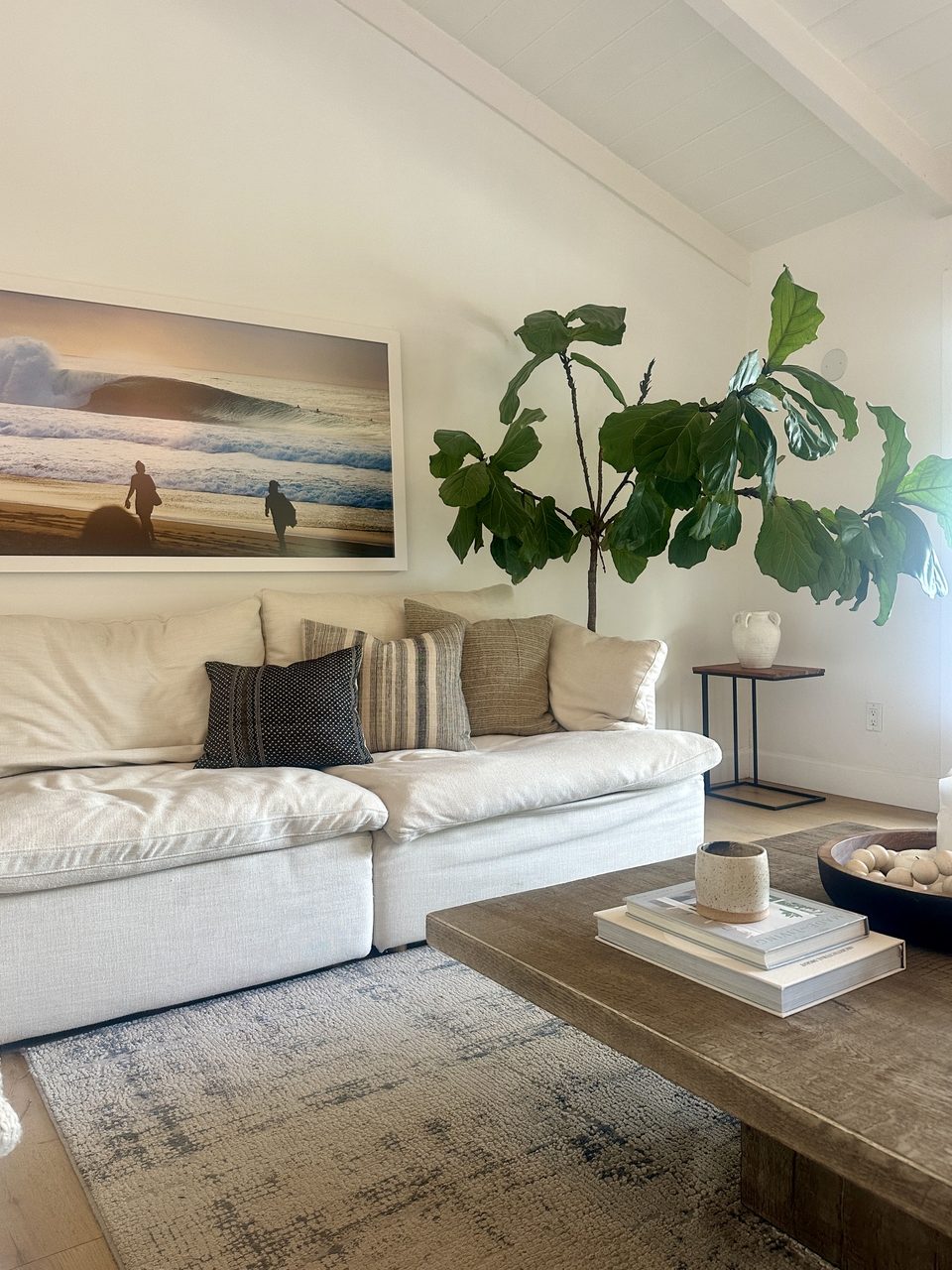 Living room seating area with layered neutrals, textiles, and a fiddle-leaf fig